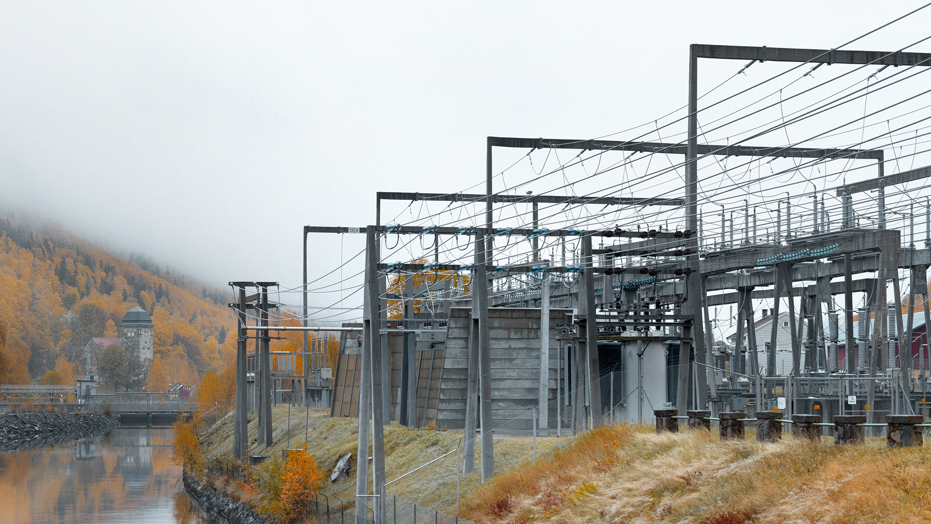 a large metal structure with a body of water in front of it