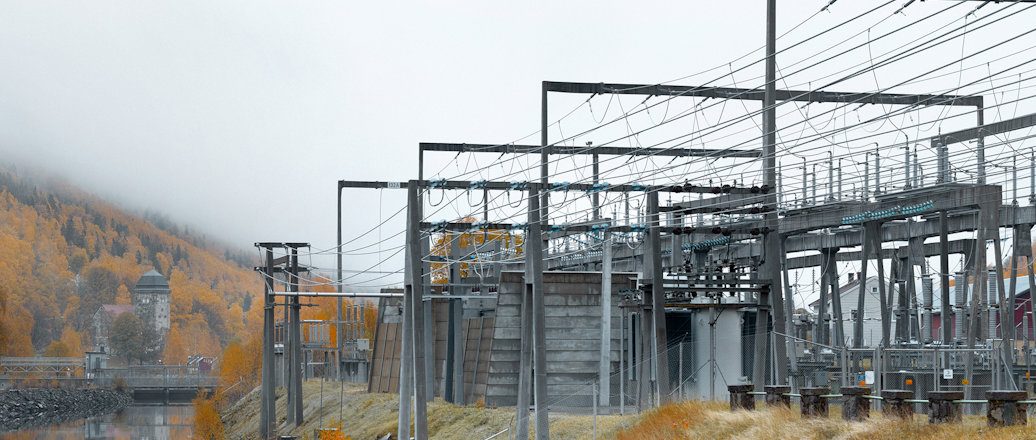 a large metal structure with a body of water in front of it