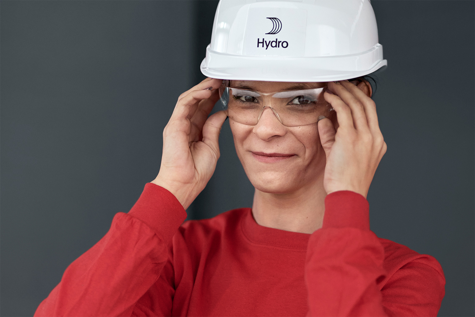 a woman wearing a white hard hat and glasses
