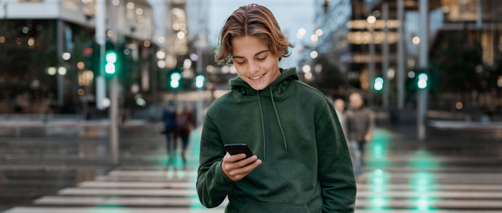 Young adult looking at his phone in urban environment