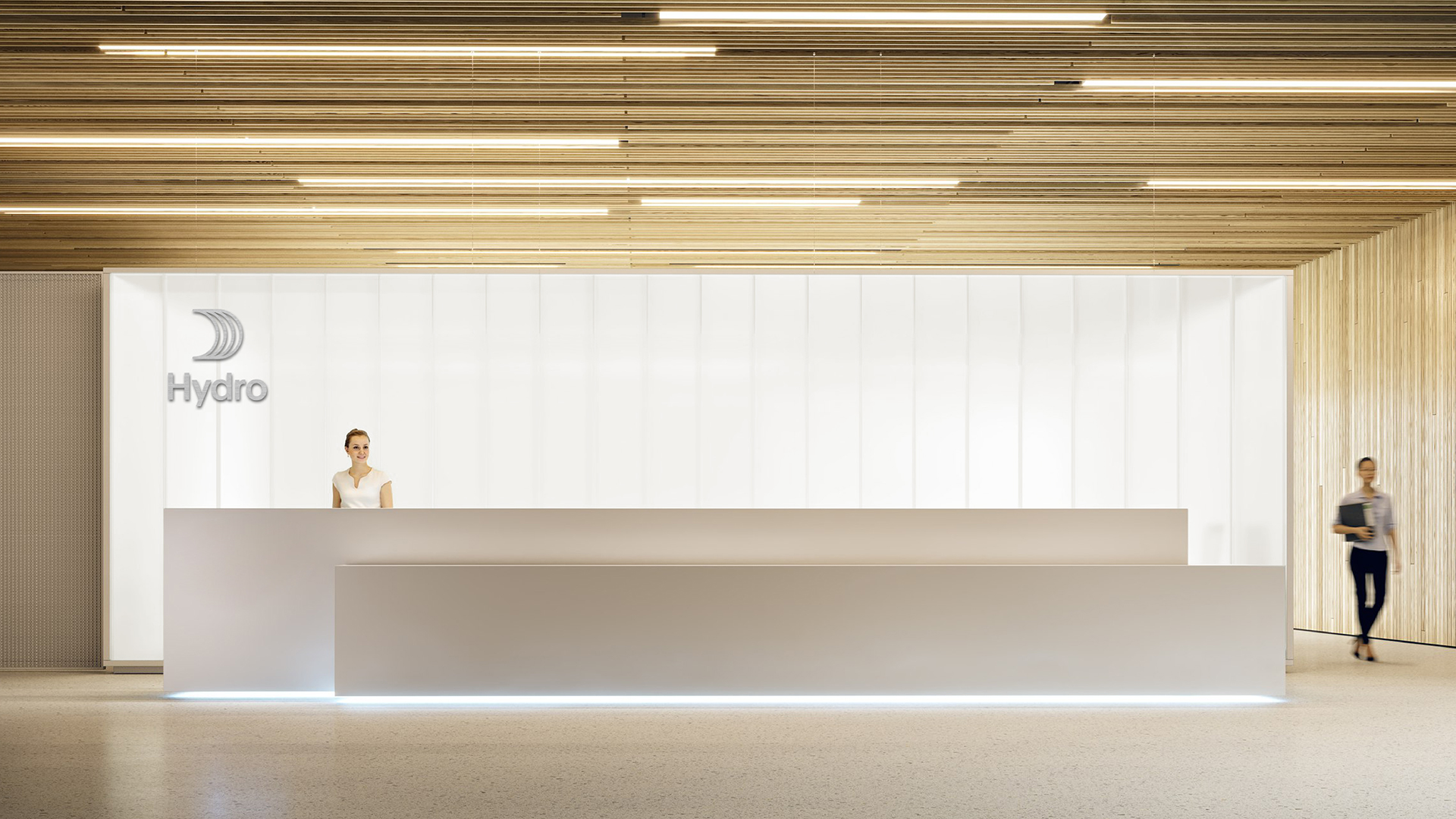 a couple of women standing in front of a white wall with black text