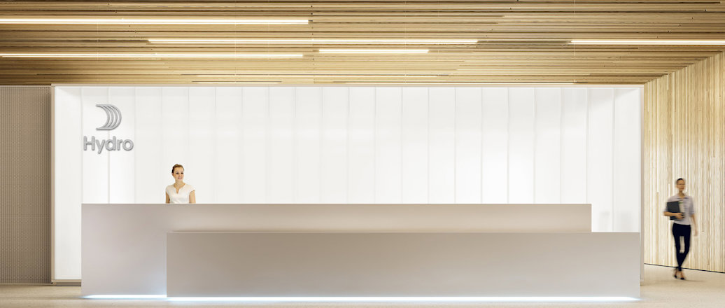 a couple of women standing in front of a white wall with black text