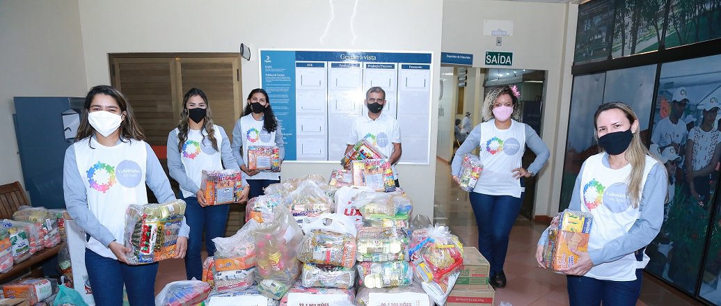 a group of women standing next to a pile of plastic bags