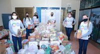 a group of women standing next to a pile of plastic bags