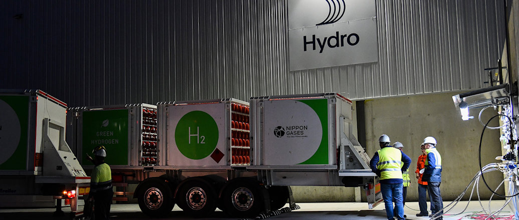 a group of men standing next to a large truck
