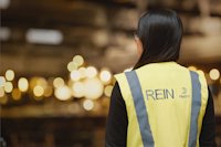 back of a person wearing a yellow jacket with blue text