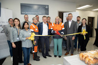 a group of people cutting a ribbon