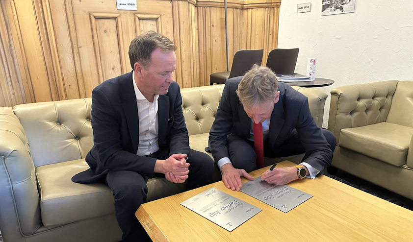 a person showing a person signing a partnership