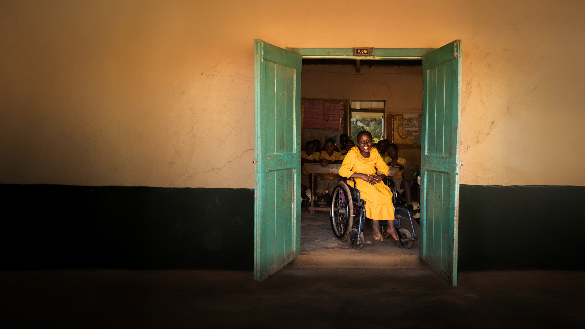 a person in a wheelchair in a room with a table and chairs