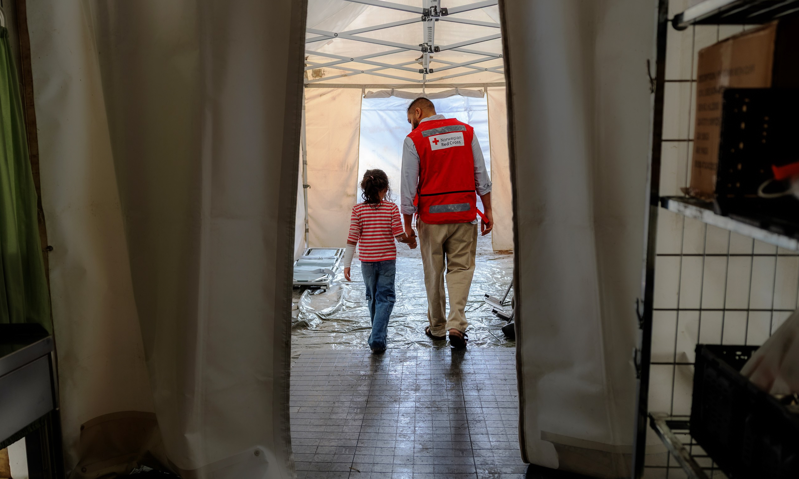 a man and child walking through a tent