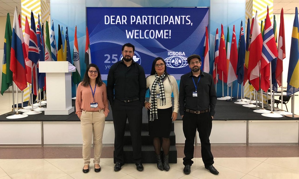 a group of people posing for a photo in front of flags