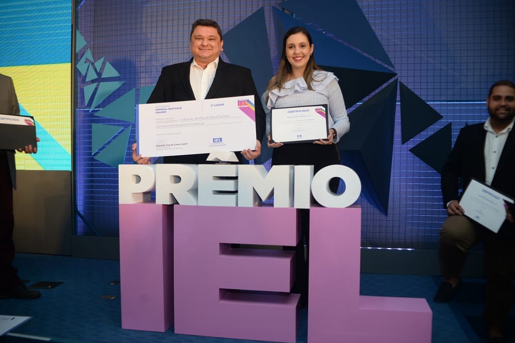 Homem e Mulher, de pé, segurando os certificados de reconhecimento