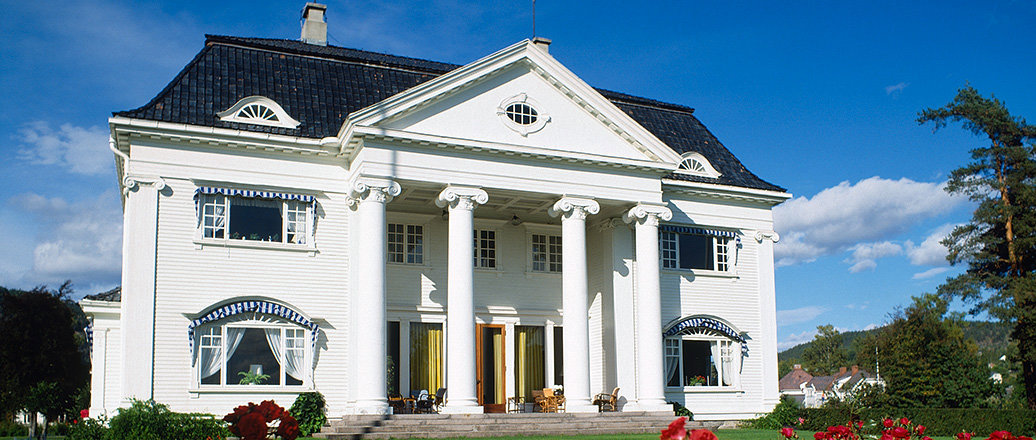 A white mansion in a rose garden