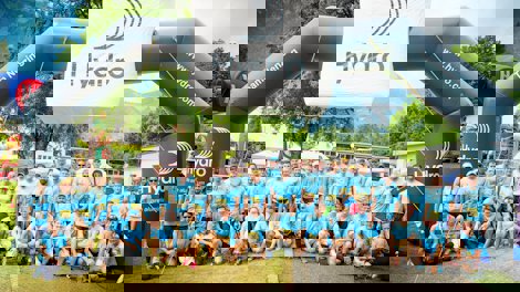 a group of people posing for a photo in front of a plane
