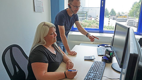 a man and a woman looking at a computer screen