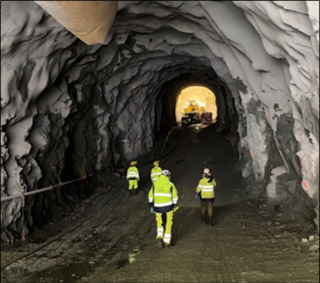 a group of men in yellow jackets in a cave