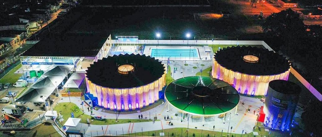 a large arena with a field and a large crowd of people