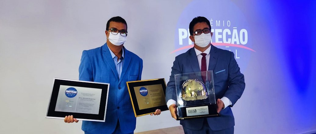 a couple of men holding awards