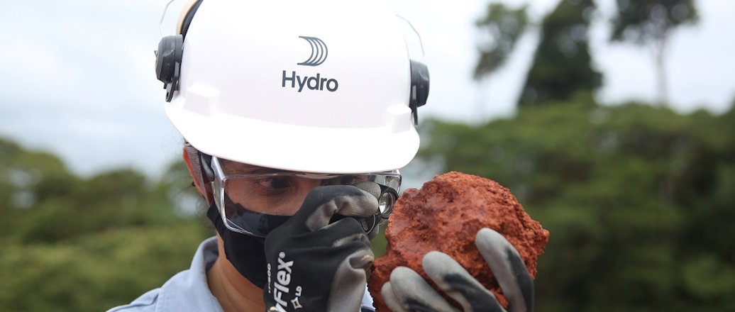 a man wearing a helmet and goggles holding a burger