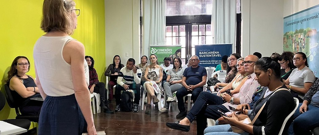 a woman standing in front of a group of people sitting in chairs