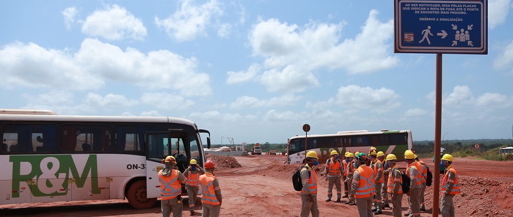 a group of people stand near some buses