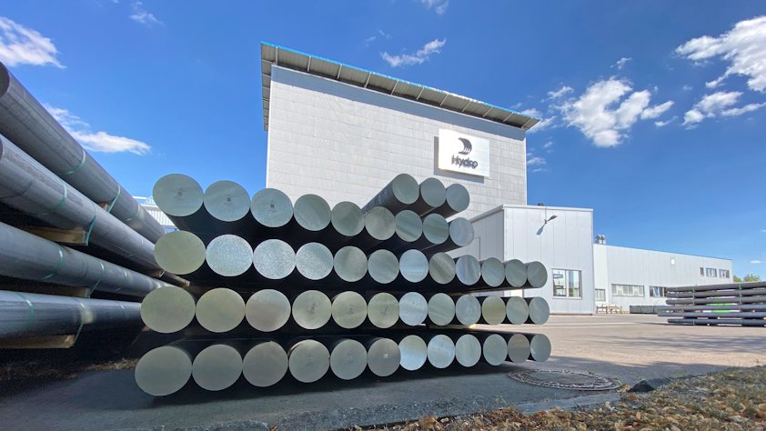 a large building with a large stack of aluminium ingots in front of it